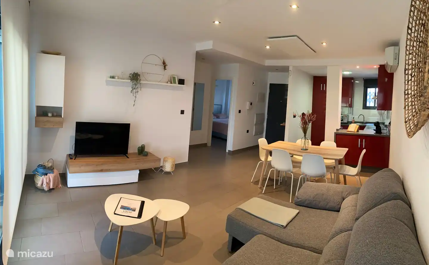 Séjour complet : coin salon, coin repas et cuisine.