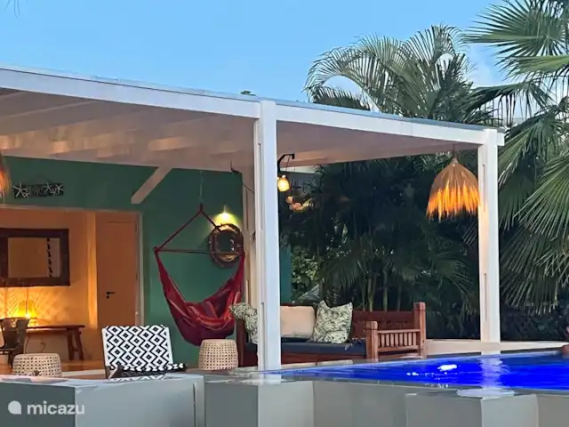 villa en Curazao, Curazao Centro, Piscadera – Invernadero Palmas Curacao La amplia terraza y la hermosa piscina que está bellamente iluminada por la noche.