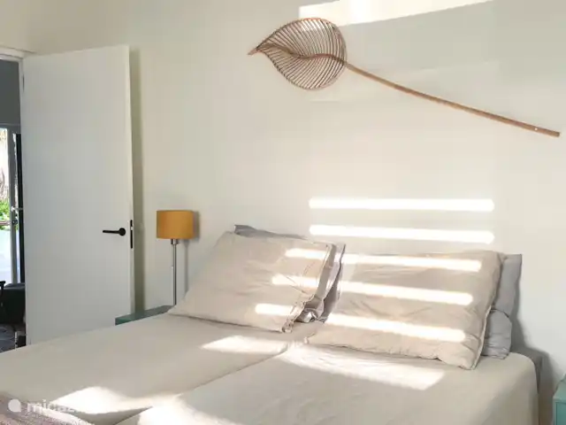 villa en Curazao, Curazao Centro, Piscadera – Invernadero Palmas Curacao El segundo dormitorio con somier de hotel de 160 x 200 cm (2x 80x200 cm), 2 mesitas de noche con lámparas, armario, aire acondicionado, ventanas de persianas de aluminio para una buena ventilación y zona de baño.