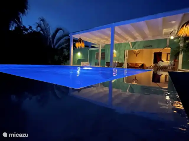 villa en Curazao, Curazao Centro, Piscadera – Invernadero Palmas Curacao La amplia terraza y la hermosa piscina que está bellamente iluminada por la noche.