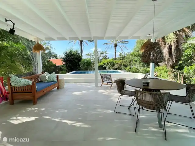 villa en Curazao, Curazao Centro, Piscadera – Invernadero Palmas Curacao La espaciosa terraza cubierta con vista a la piscina y al jardín tropical.