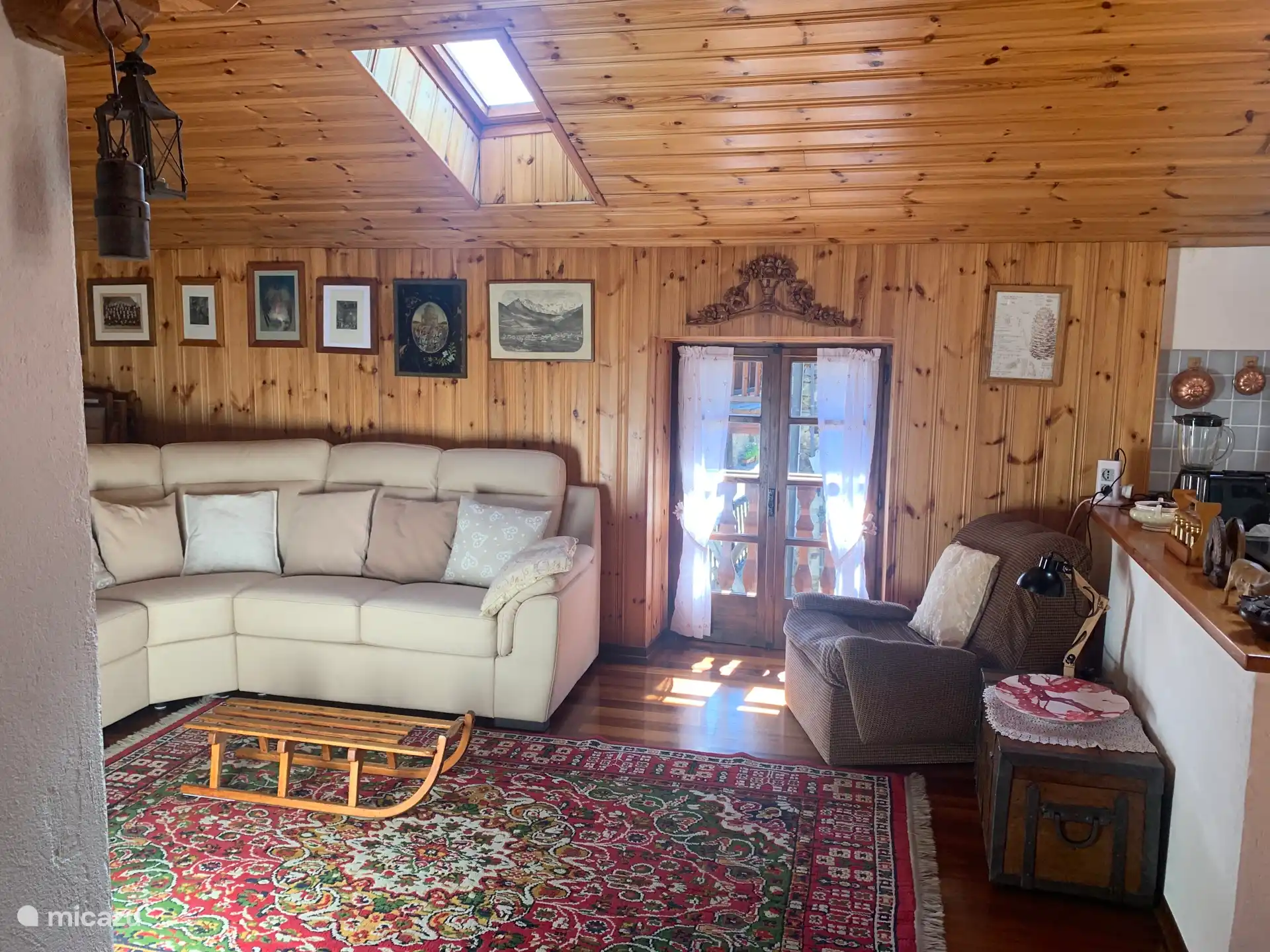 Das Wohnzimmer mit Küchen- und Essbereich. Die Materialien sind weich und samtig: Woll- oder Flanelllaken für das Sofa und die Kissen, Wolle für die Teppiche.
