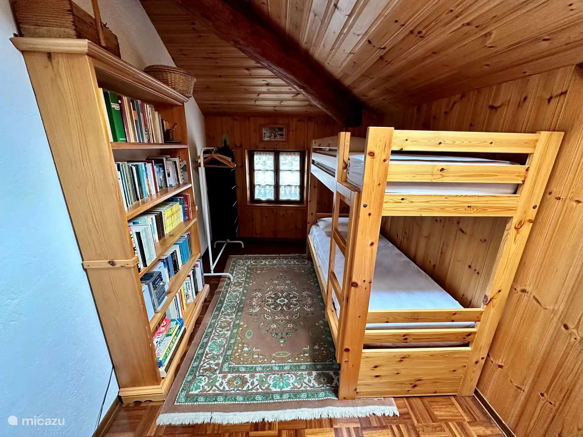 Gemütliches Schlafzimmer mit Etagenbetten und Bücherregal zur Aufbewahrung von Büchern.