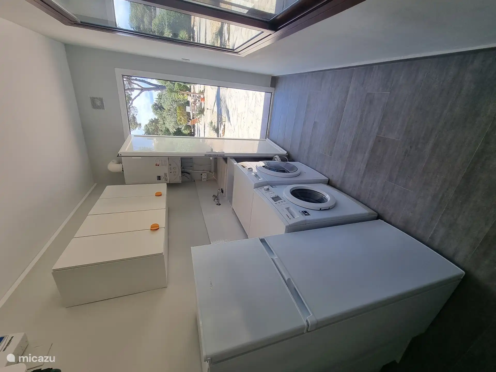 Im Hauswirtschaftsraum gibt es eine Waschmaschine, einen Trockner und einen 2. Kühlschrank