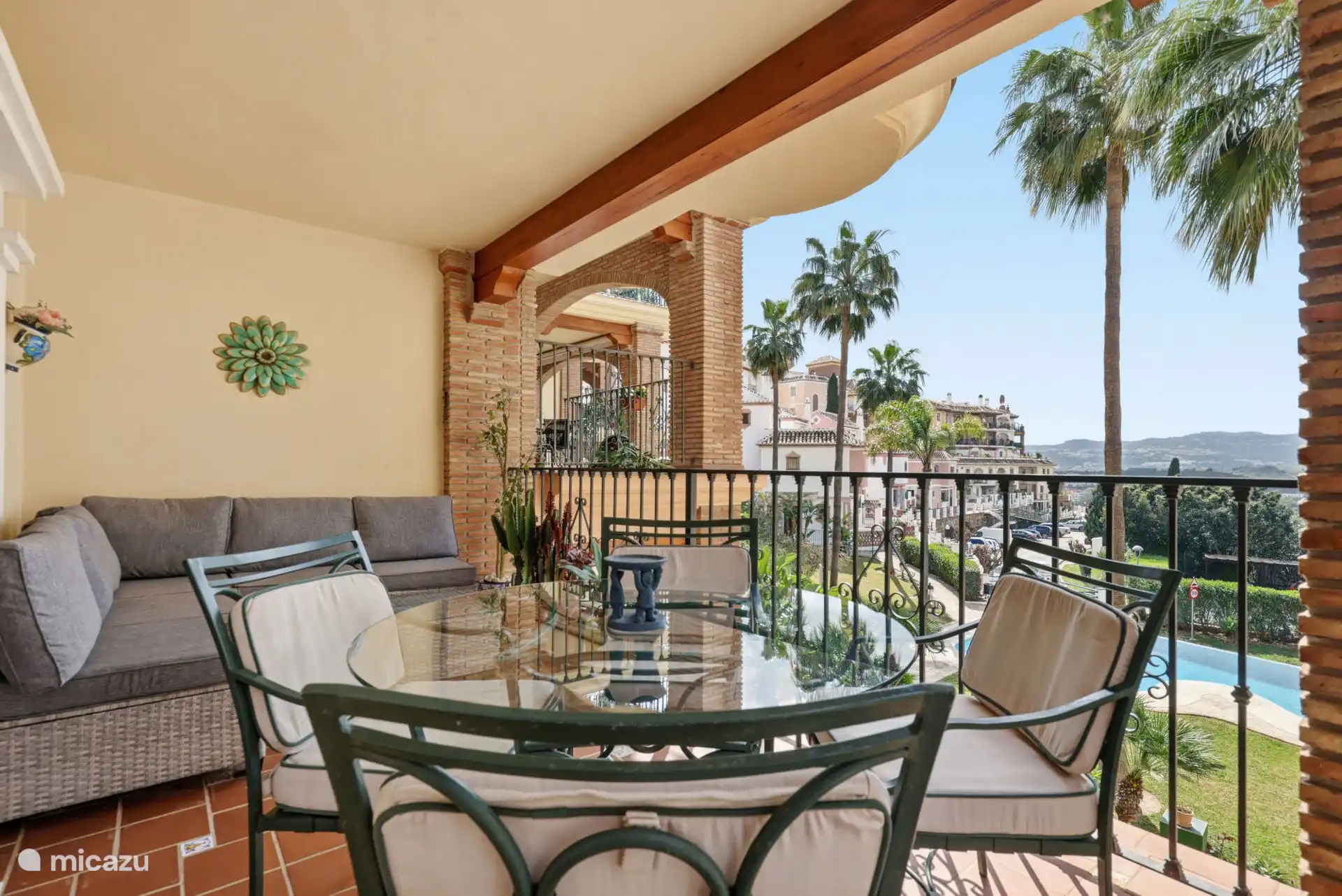 Terras met zit- en eetgedeelte met uitzicht op het zwembad en de tuinen