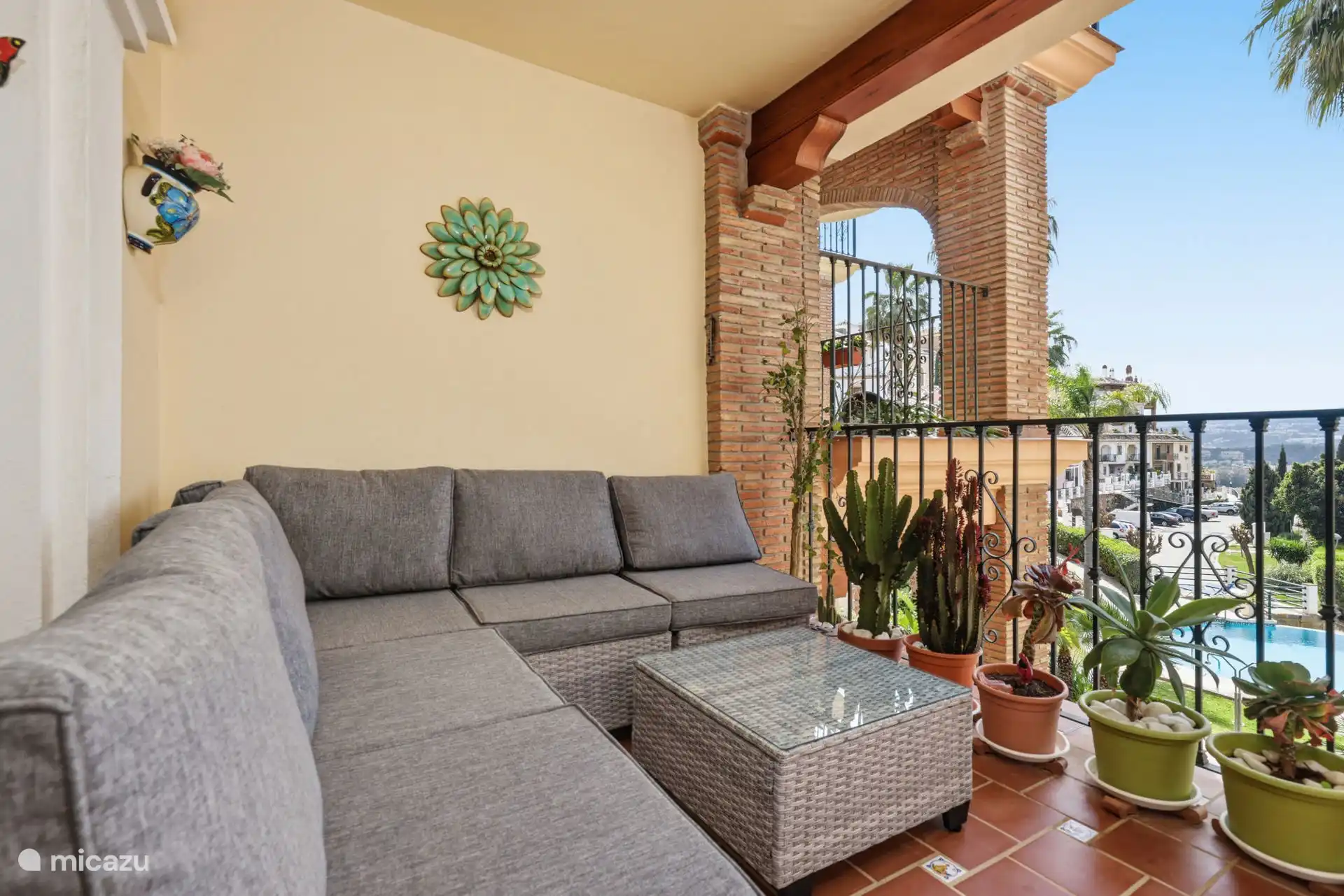 Terras met zit- en eetgedeelte met uitzicht op het zwembad en de tuinen