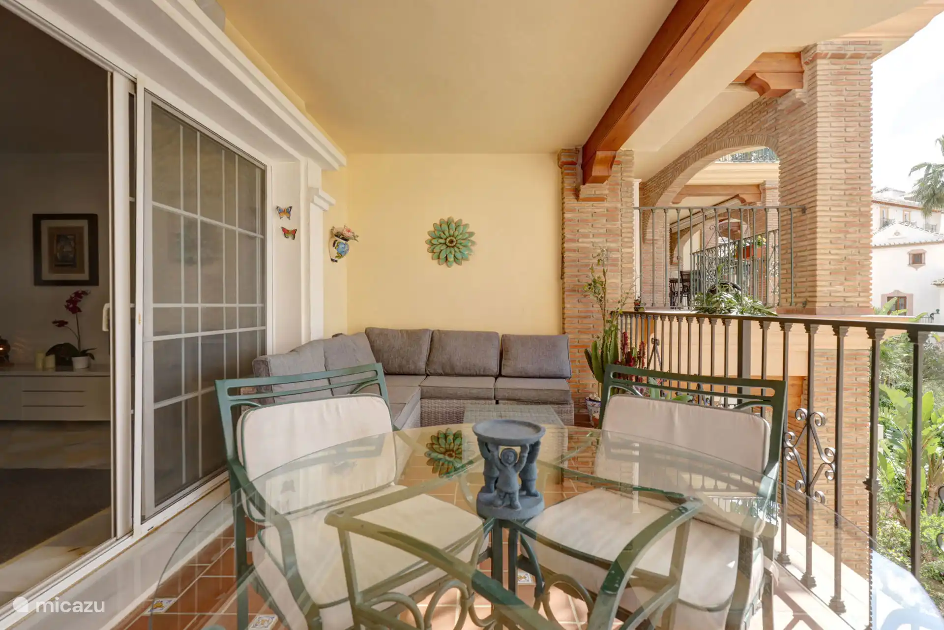 Terras met zit- en eetgedeelte met uitzicht op het zwembad en de tuinen