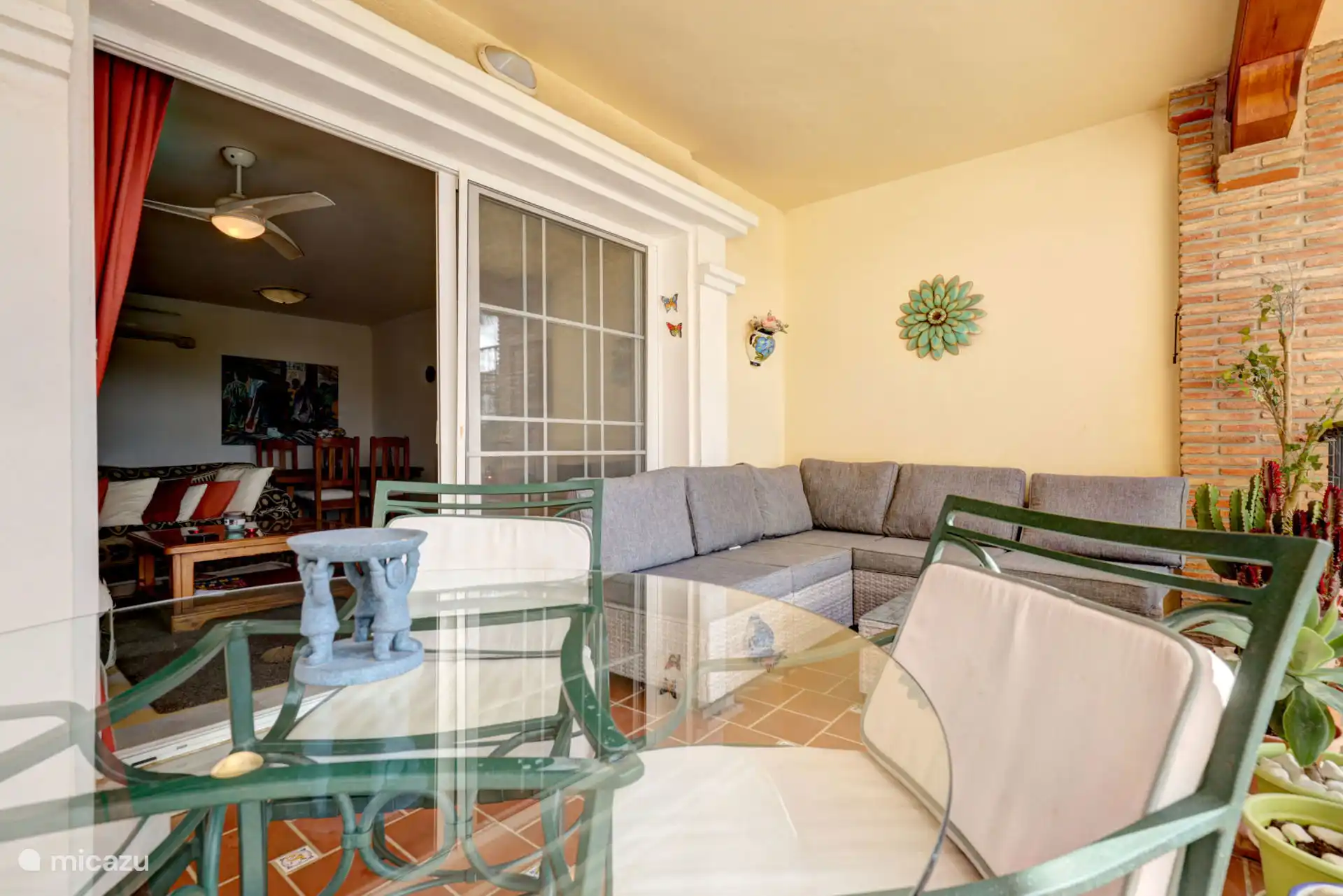 Terras met zit- en eetgedeelte met uitzicht op het zwembad en de tuinen