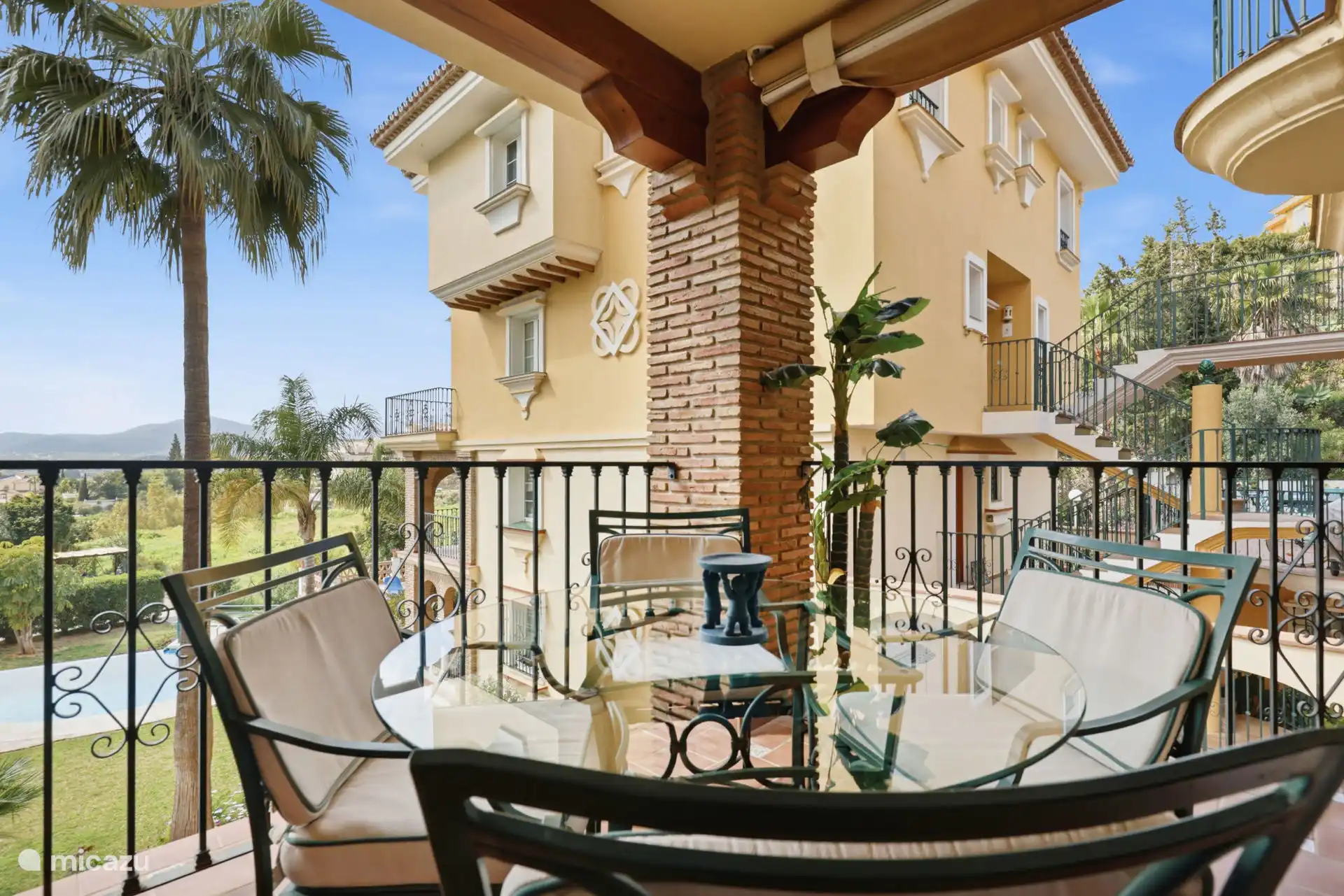 Terras met zit- en eetgedeelte met uitzicht op het zwembad en de tuinen