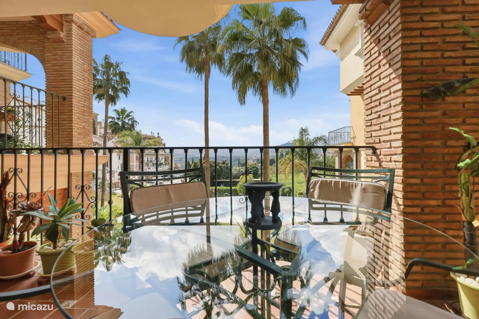 Terras met zit- en eetgedeelte met uitzicht op het zwembad en de tuinen