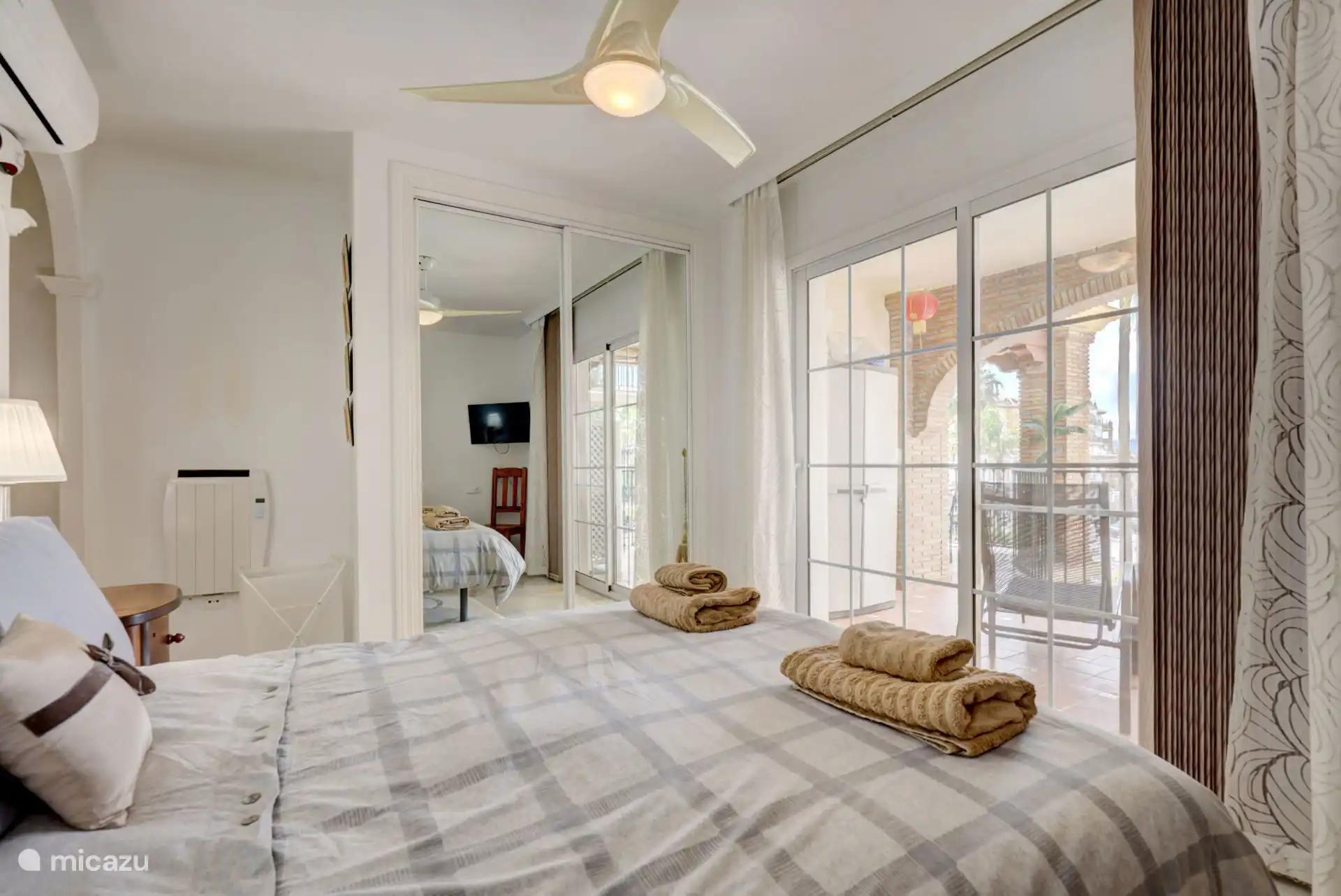 Hoofdslaapkamer met eigen badkamer en toegang tot het terras.