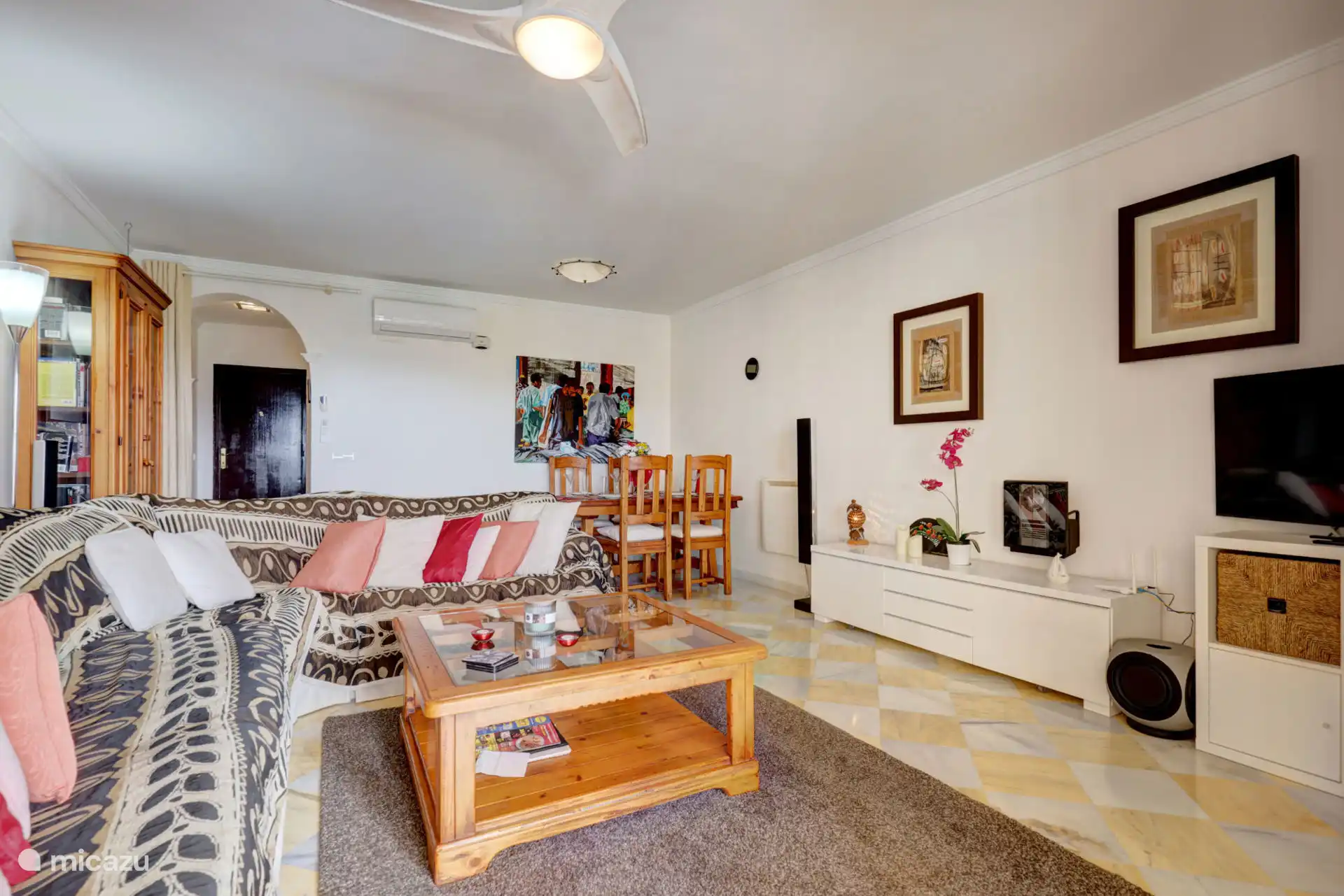 Zitkamer met eetruimte en toegang tot het terras met uitzicht op zwembad en tuin