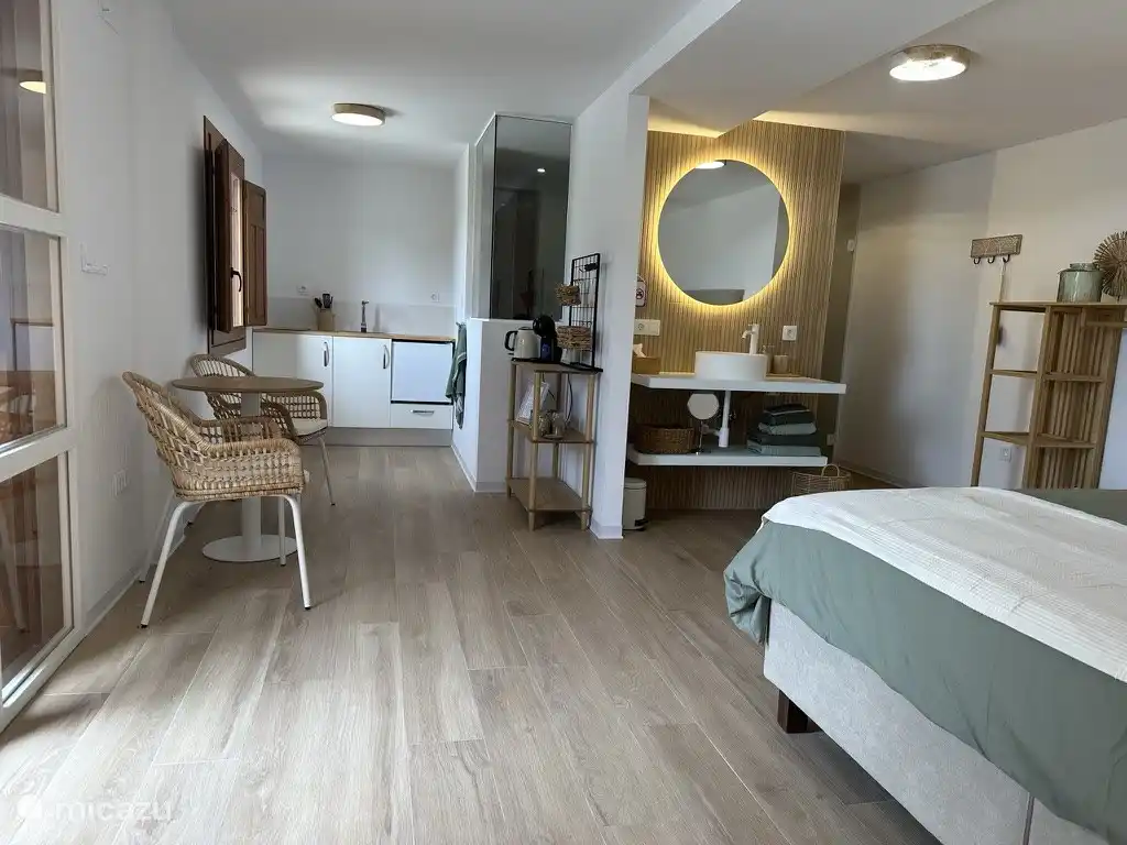 Die Wohnung verfügt über eine kleine Küche mit Herd, Kühlschrank und Kücheninventar.