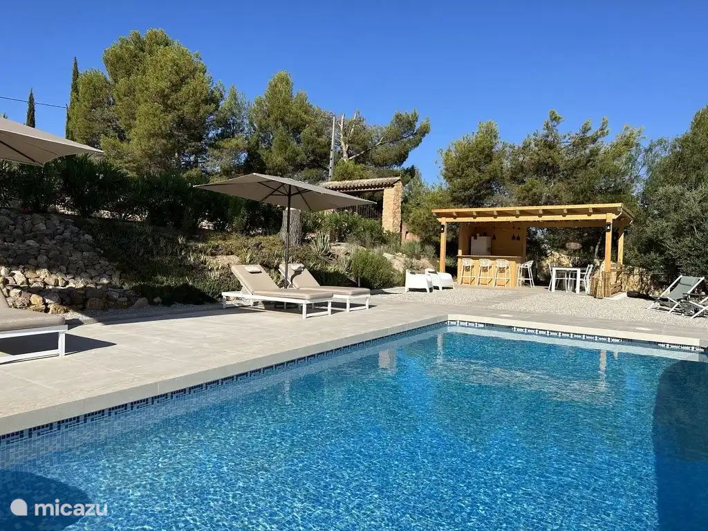 Swimmingpool mit luxuriösen Sonnenliegen und der Honesty Bar.
