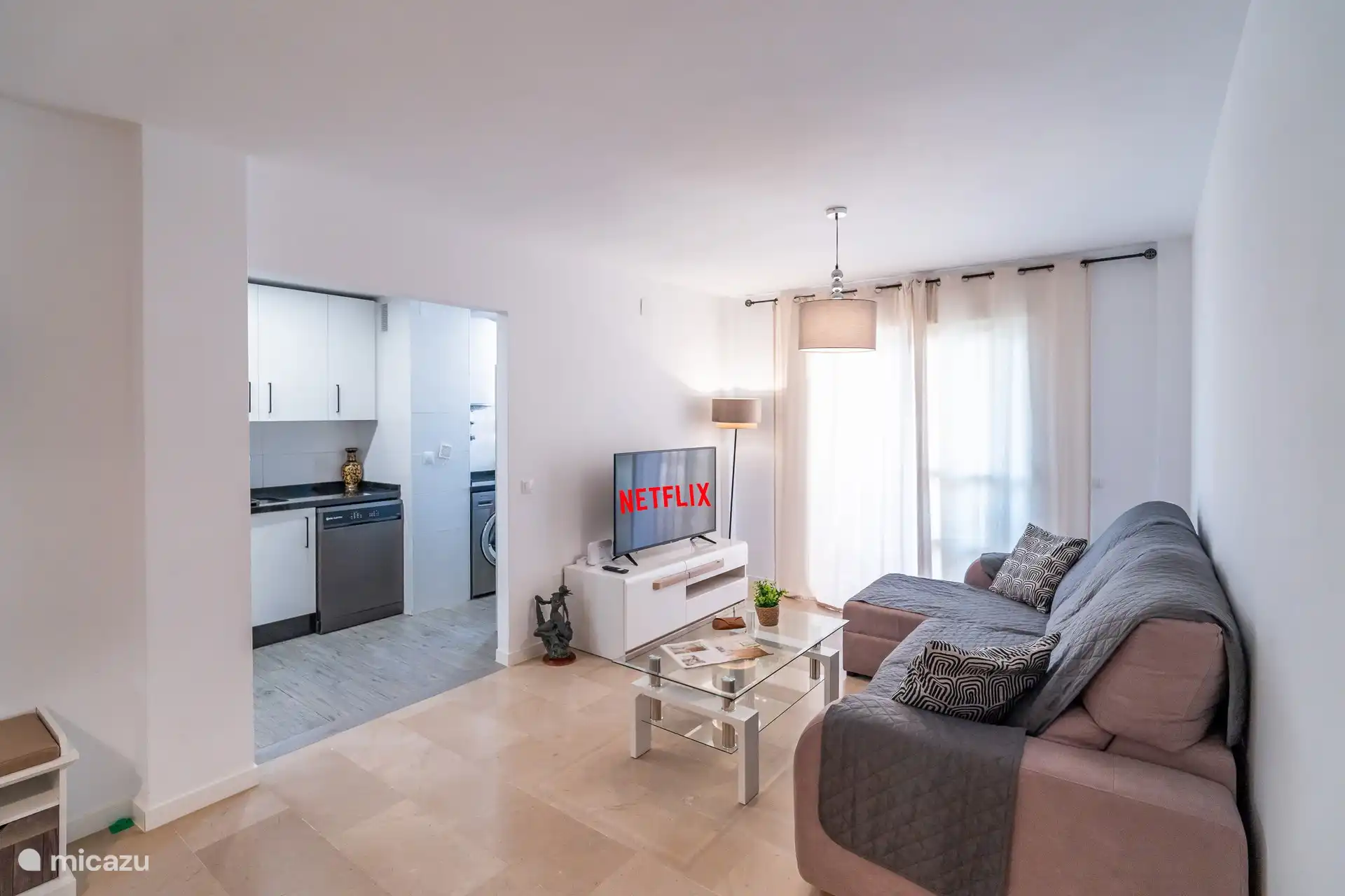 Salon, smart tv, mène à la cuisine. 