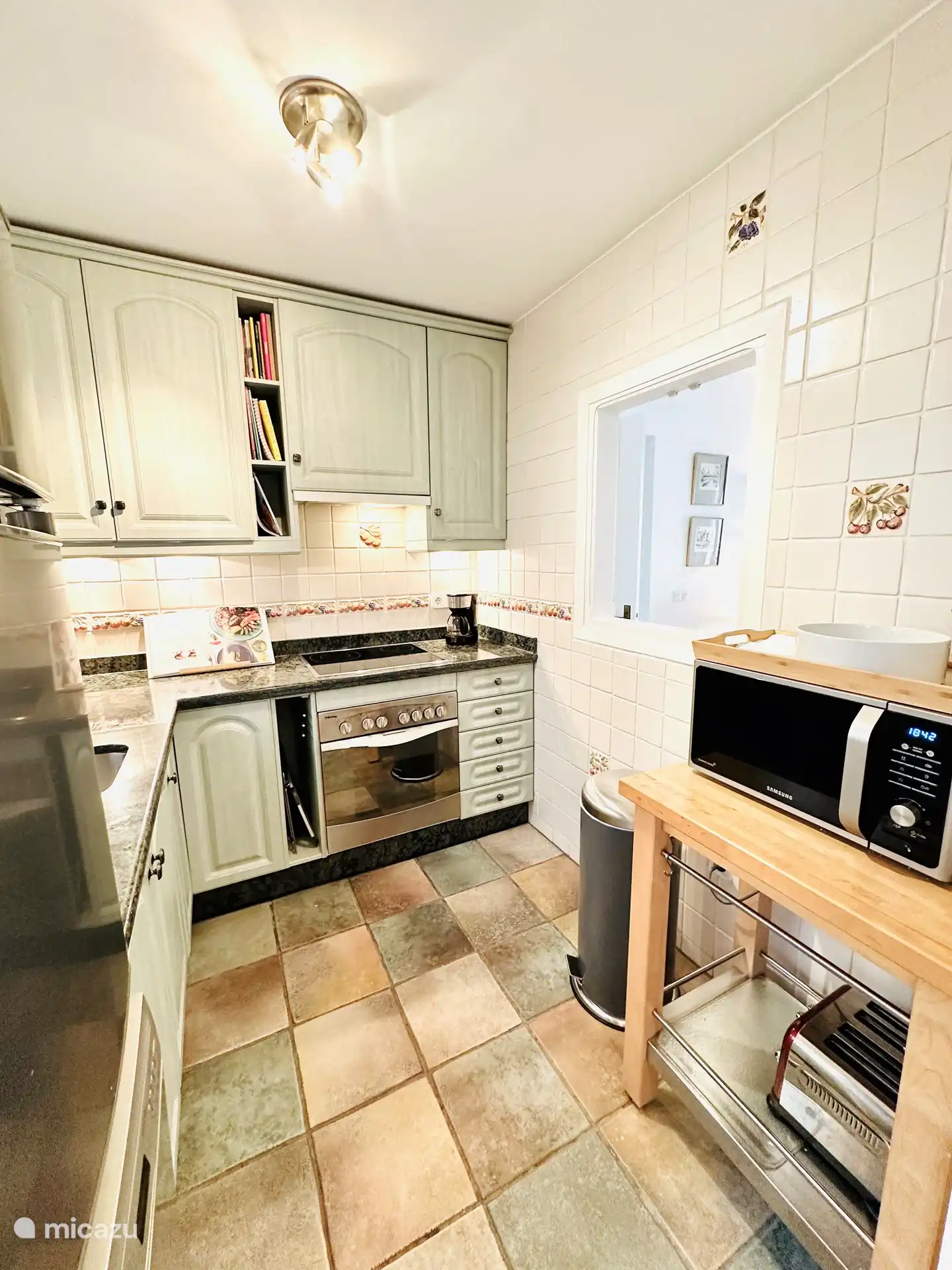 The kitchen is equipped with a refrigerator/freezer, oven, microwave, dishwasher, coffee maker and kettle.