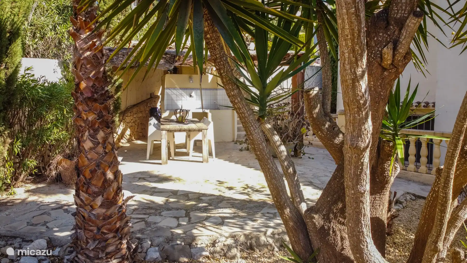 Gran jardín privado al aire libre con zona de estar y mesa de comedor con sillas - Apartamento vacacional Merluza en Moraira, Costa Blanca