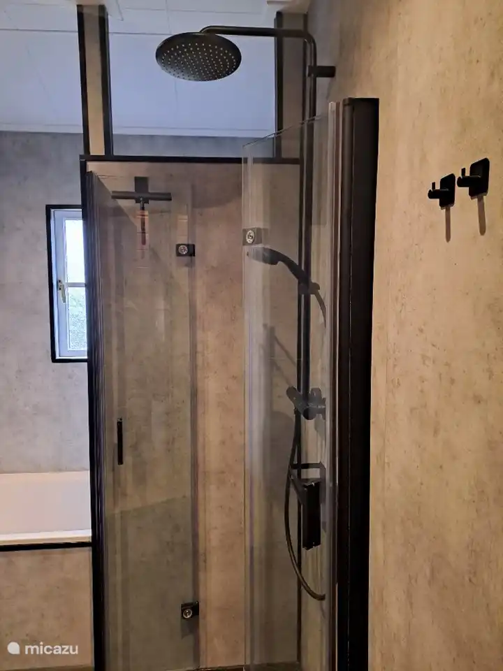 Badezimmer mit Badewanne und Regendusche