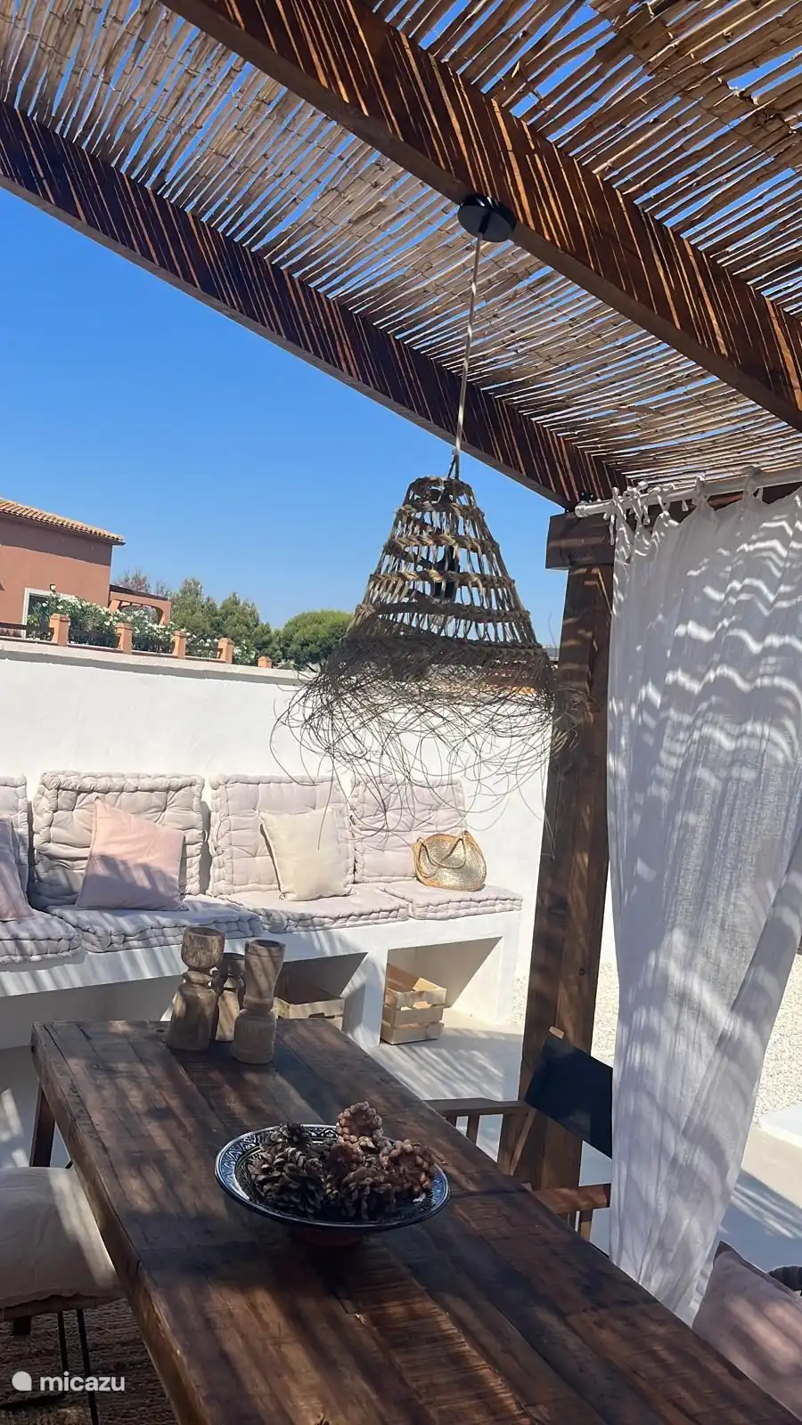 Ein Outdoor-Sofa mit Kissen zum Entspannen. Die Sonne ist die Erste, die hier ist und als Erste geht, um nach einem langen, sonnigen Tag Schatten zu suchen.