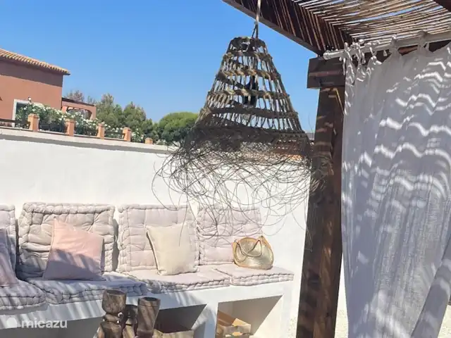 Casa de Verano huren in Spanje, Costa Blanca, Busot - bungalow Een buitenbank met kussens, waar je lekker op kunt chillen. De zon is hier als eerst en ook als eerste weer weg, schaduw zoeken na een lange zonnige dag.