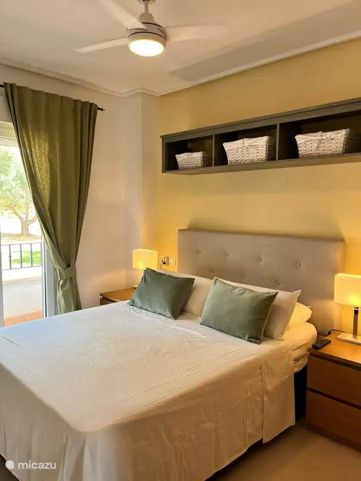 Dormitorio con cama doble con un cómodo colchón y almohadas para un sueño reparador. TV, armario empotrado, ventilador de techo con mando a distancia. Mamparas para ventanas y mamparas opacas. Puertas francesas a una pequeña terraza al aire libre en la parte delantera del apartamento.