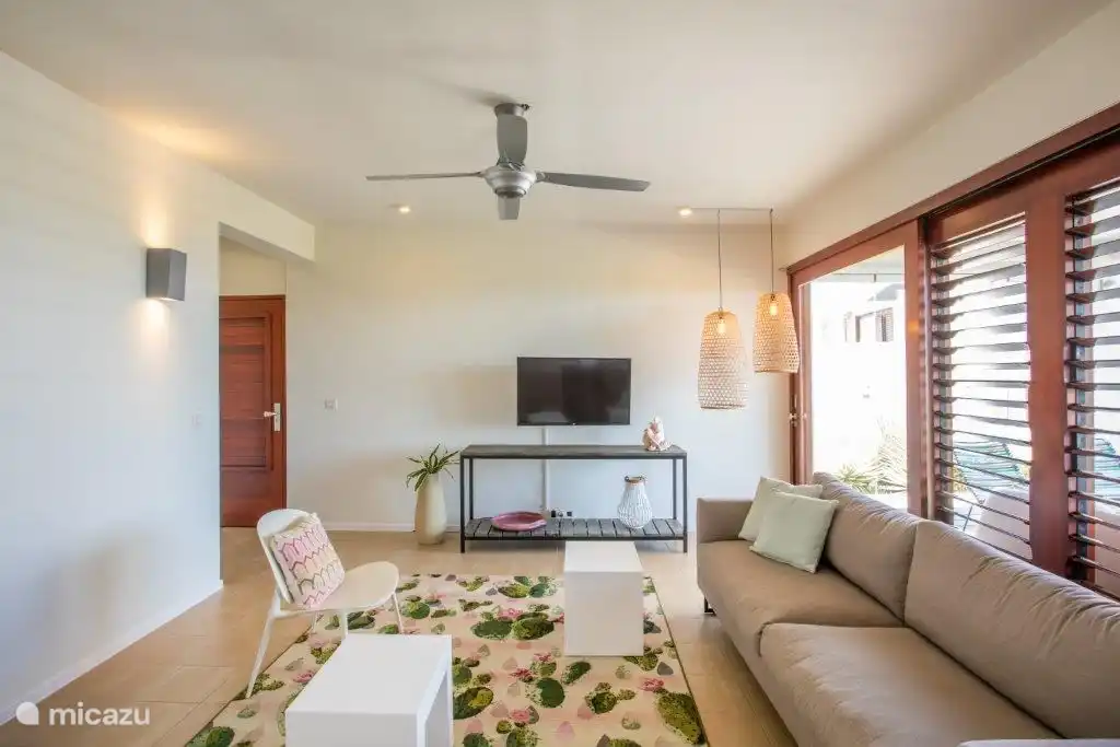 Salon spacieux à l'intérieur avec porte d'entrée à gauche.