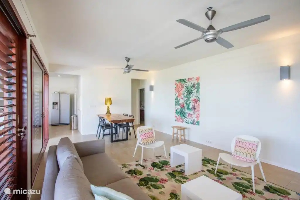 Salon intérieur spacieux et couloir menant aux chambres.