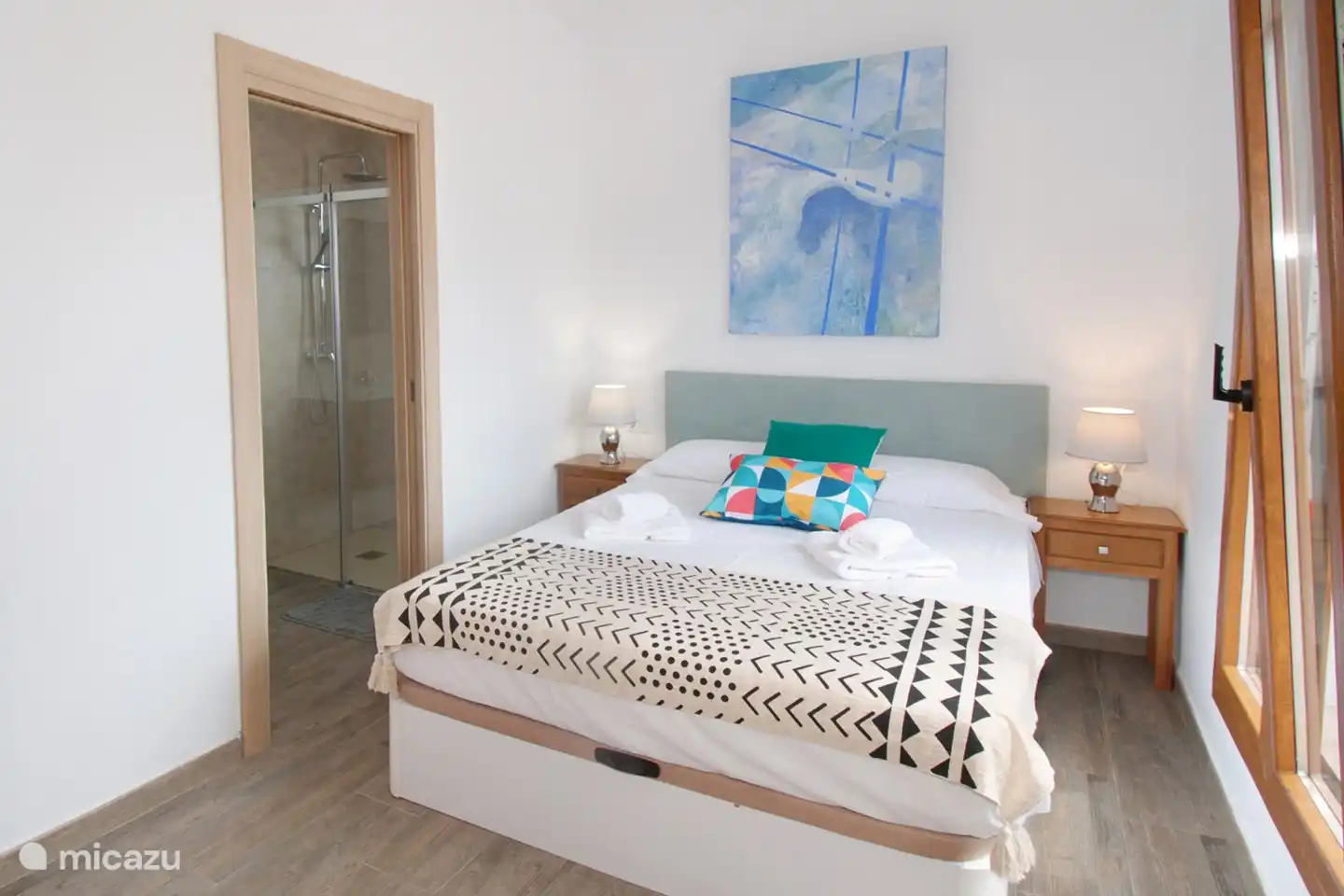 Das Schlafzimmer mit eigenem Bad und großen Fenstern.