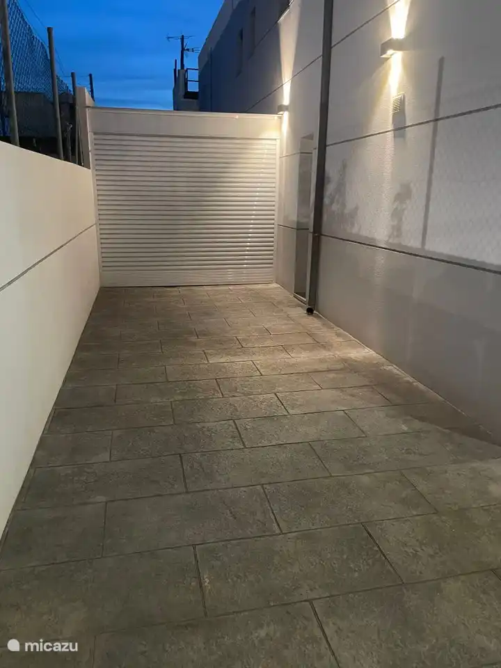 Débarras à l’arrière de la maison (ici se trouvent la machine à laver / sacs de golf / corde à linge, chaises longues 
Le local de stockage peut être ouvert et fermé dans n’importe quelle position souhaitée au moyen du volet roulant électrique