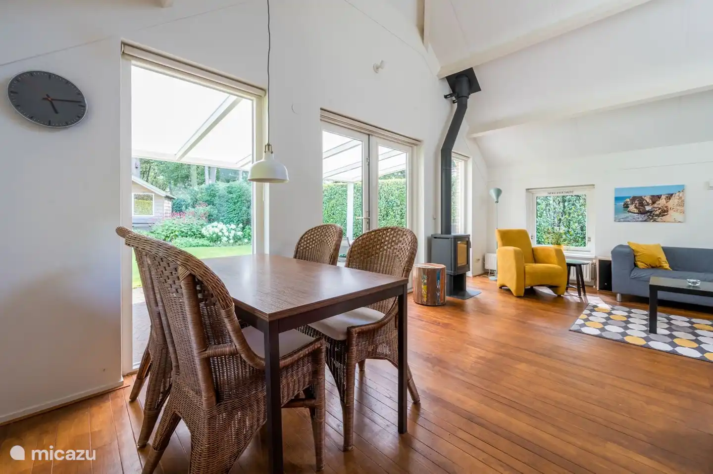 Wohnzimmer mit Holzofen und Blick auf den Garten