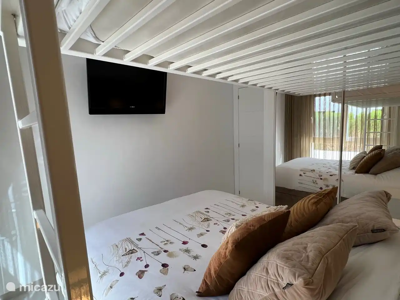 Schlafzimmer 2 mit Doppelbett und Hochbett, Klimaanlage, großem Schrank, Nachttischen, Moskitonetzen und Fernseher.