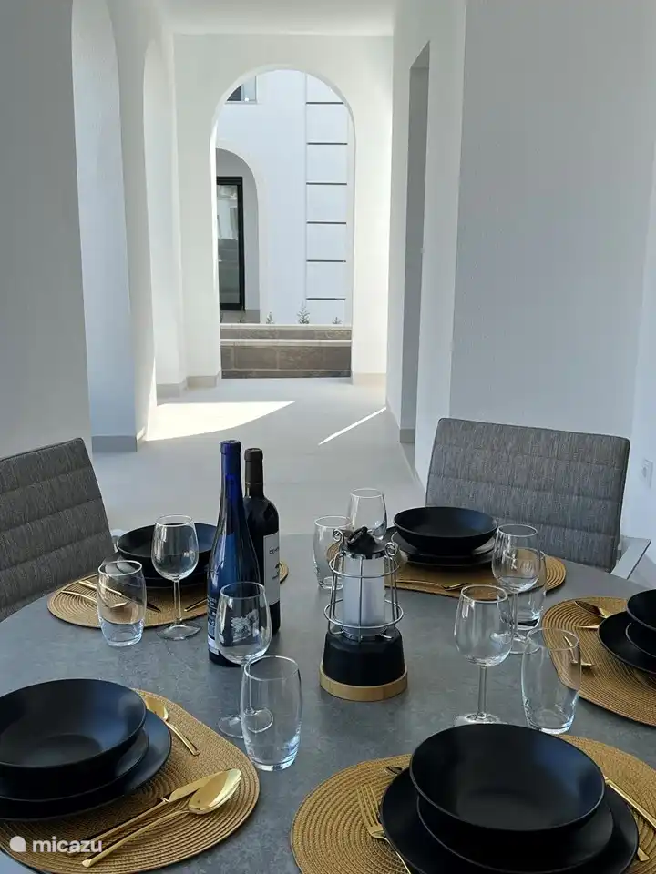 Esstisch im Freien auf der überdachten Terrasse mit 5 Esszimmerstühlen inklusive Kissen und Blick auf den Pool.