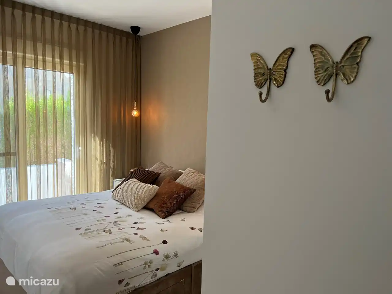 Hauptschlafzimmer mit Doppelbett, Klimaanlage, großem Schrank, Nachttischen, Moskitonetzen, Schiebetüren mit sonnigem privatem Loungebereich im Freien und Fernseher.