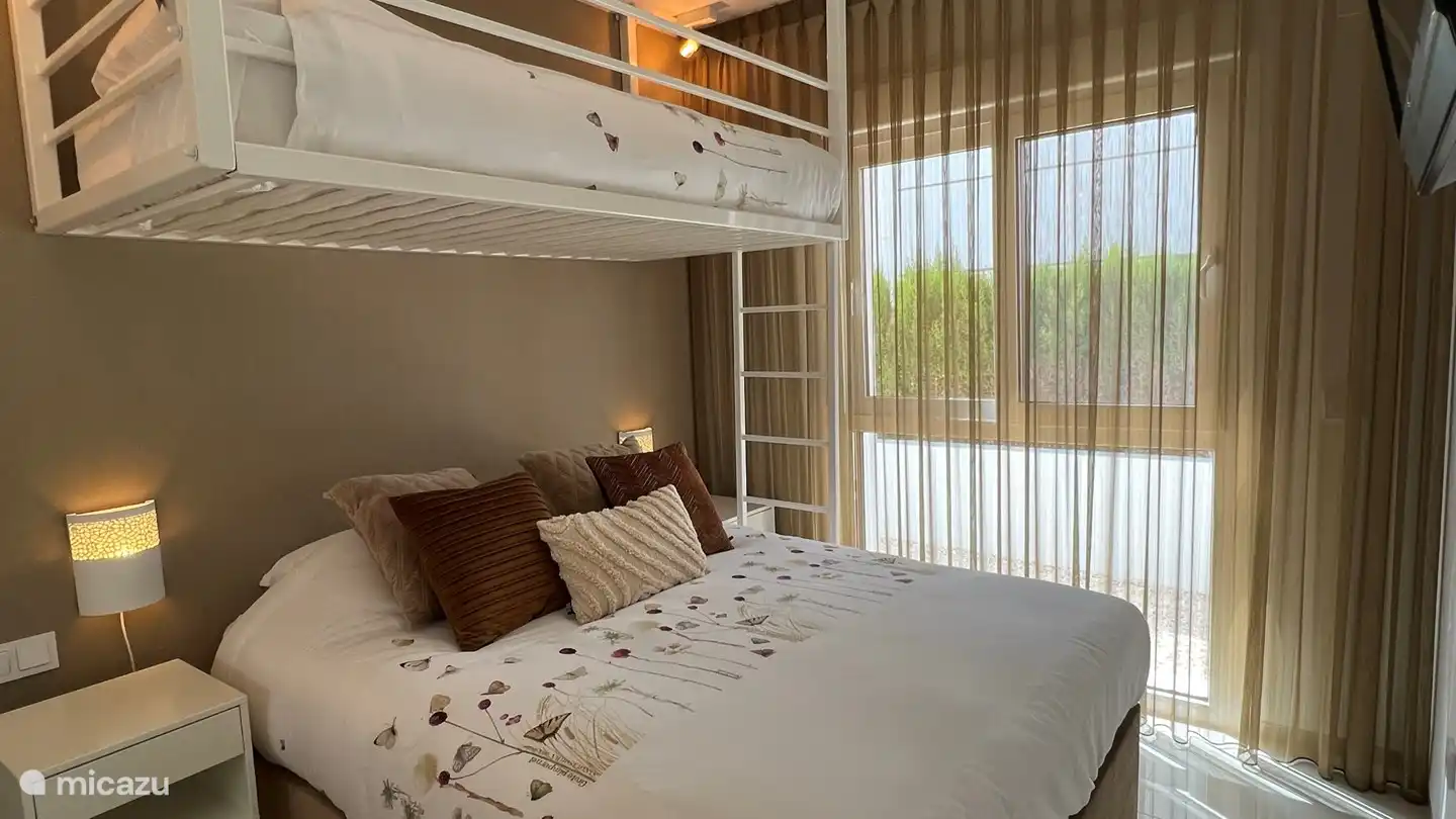 Schlafzimmer 2 mit Doppelbett und Hochbett, Klimaanlage, großem Schrank, Nachttischen, Moskitonetzen und Fernseher.