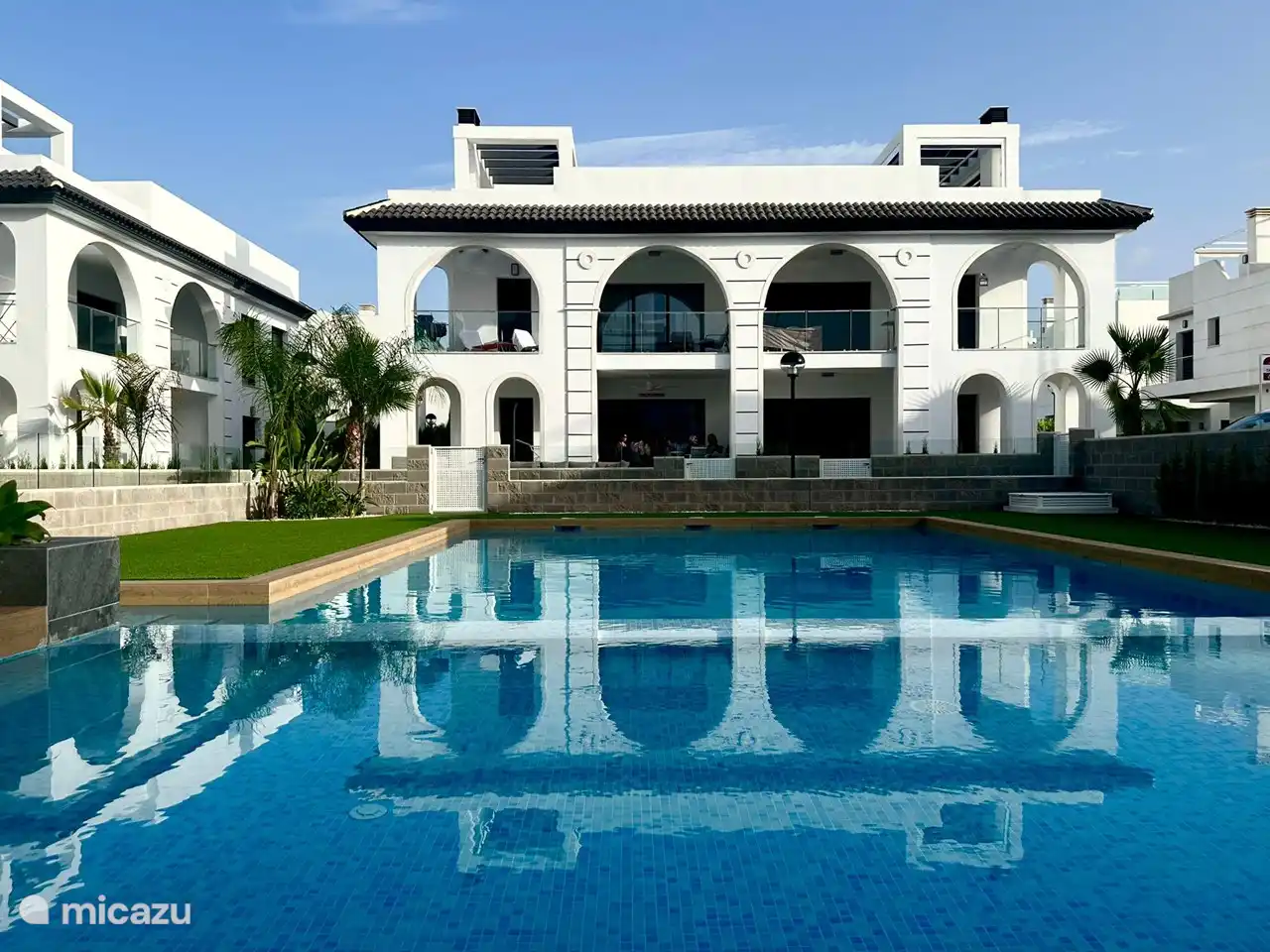 Sonniges Schwimmbad mit Sonnenliegen und Sonnenschirmen. Separates Kinderbecken.