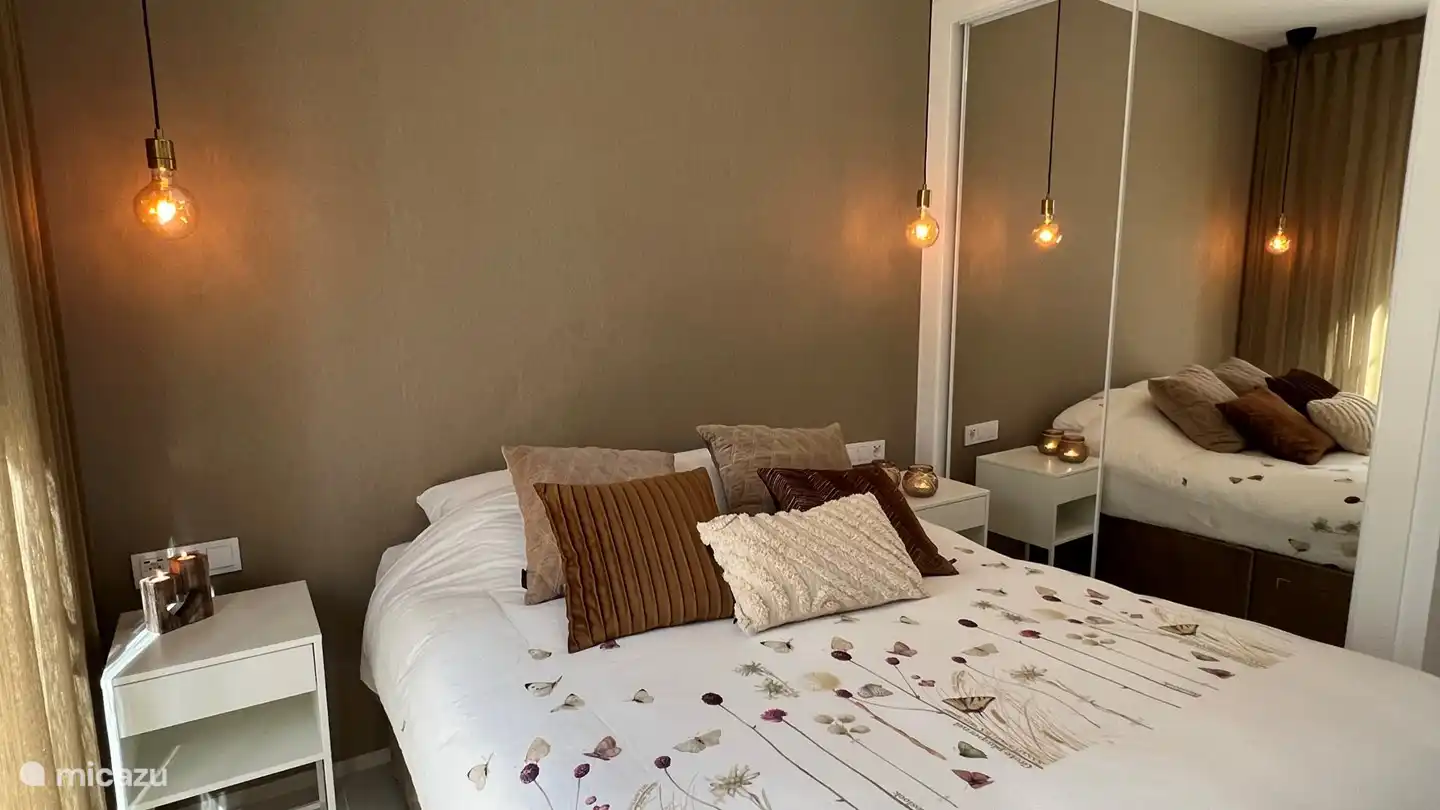 Hauptschlafzimmer mit Doppelbett, Klimaanlage, großem Schrank, Nachttischen, Moskitonetzen, Schiebetüren mit sonnigem privatem Loungebereich im Freien und Fernseher.