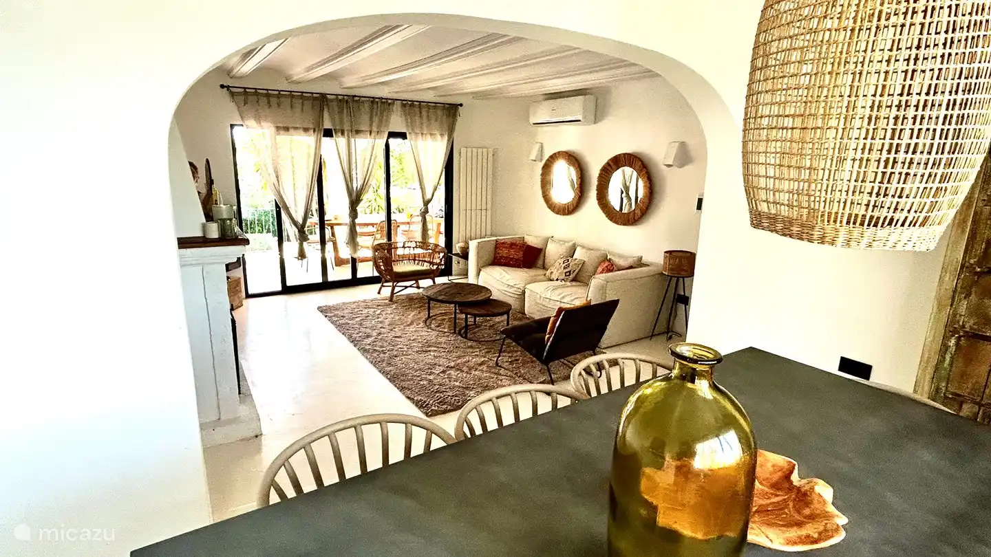 The living room is cozy with a fireplace and television. The dining table for 8 people is also located in this open space. Cozy Ibiza style furnishings combined with homely coziness.