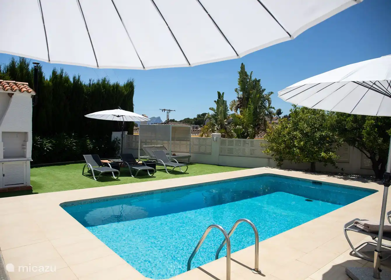 Nehmen Sie ein erfrischendes Bad und entspannen Sie anschließend in der Sonne auf den bequemen Sonnenliegen