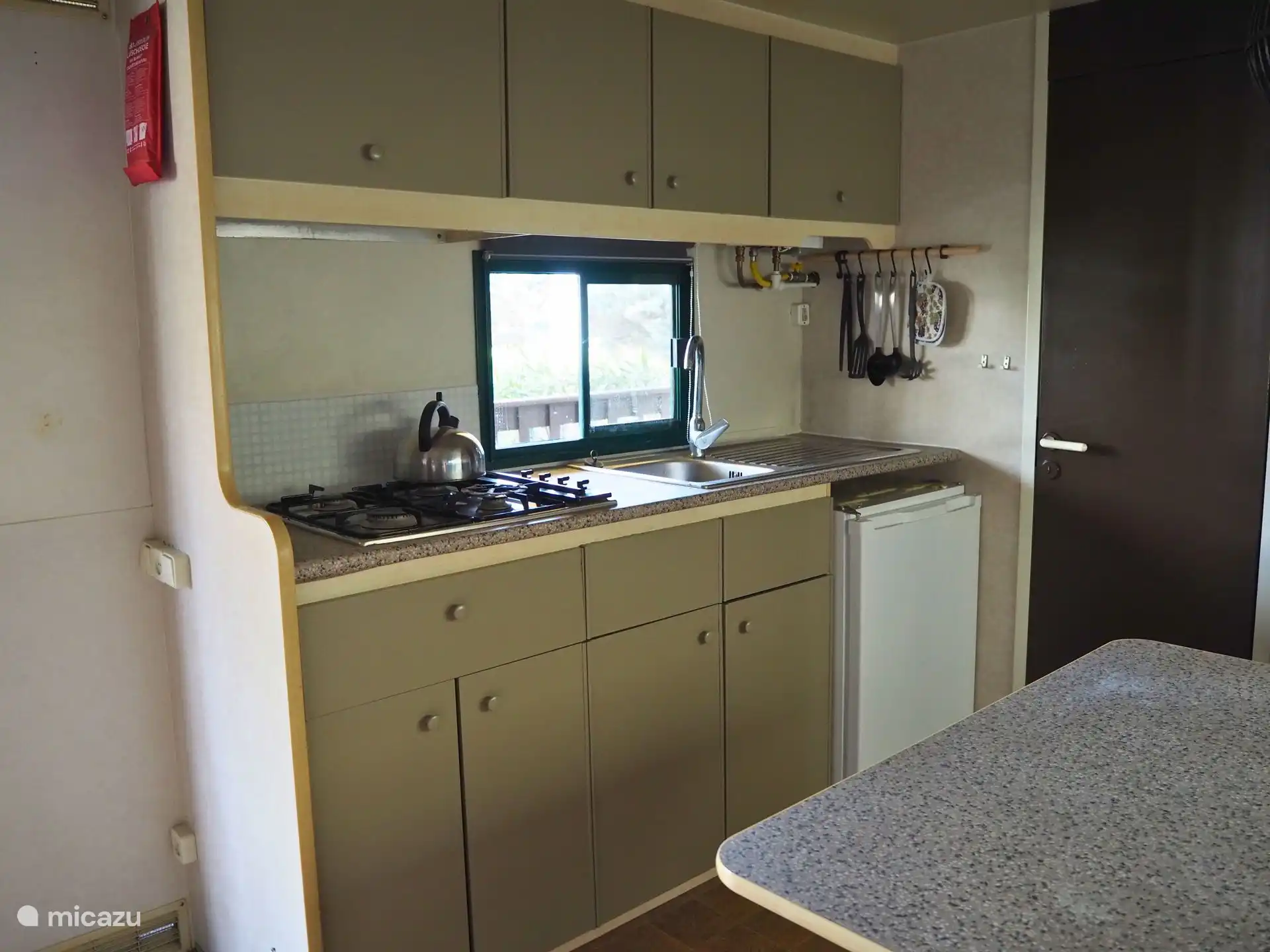 Die offene Küche verfügt über einen 4-Flammen-Gasherd, Kühlschrank mit Gefrierfach und umfangreiches Inventar.