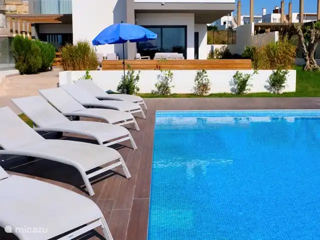 villa en Portugal, Costa de Lisboa, Ribamar – Sapateira Hay tumbonas alrededor de la piscina.
