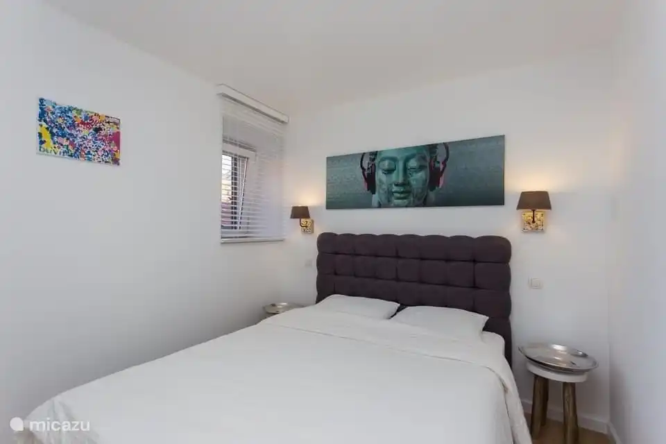 Schlafzimmer mit Einbauschränken, Klimaanlage und Fliegennetz am Fenster