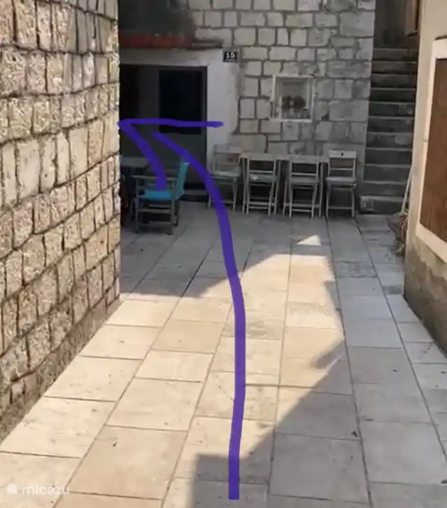 Gehen Sie über den Platz und in der hinteren linken Ecke befindet sich das Haus