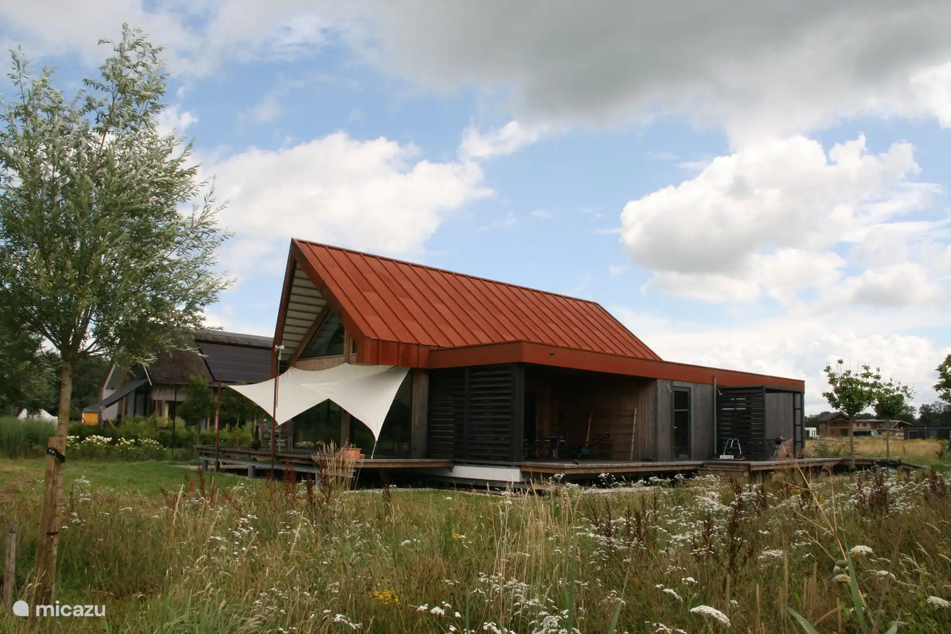 Wir wohnen in der anderen Ecke des Hauses und halten es mit Sonnenschutztüchern kühl. 