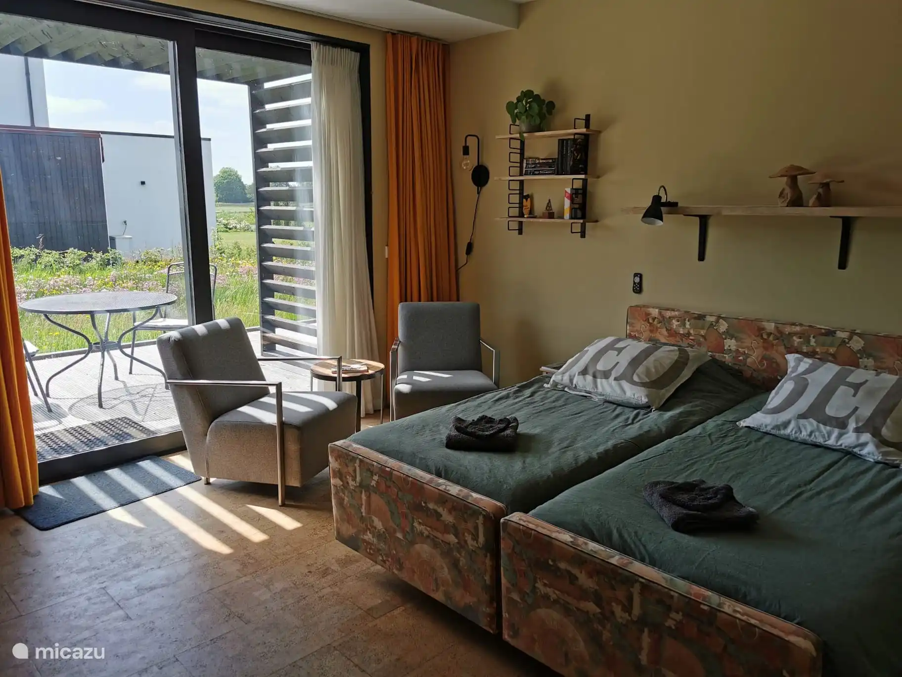 Der Haupteingang ist eine breite Schiebetür. Das Zimmer verfügt über wunderbare Betten, die bei Bedarf auch geteilt werden können. Und natürlich ein paar Stühle zum Lesen oder Fernsehen.