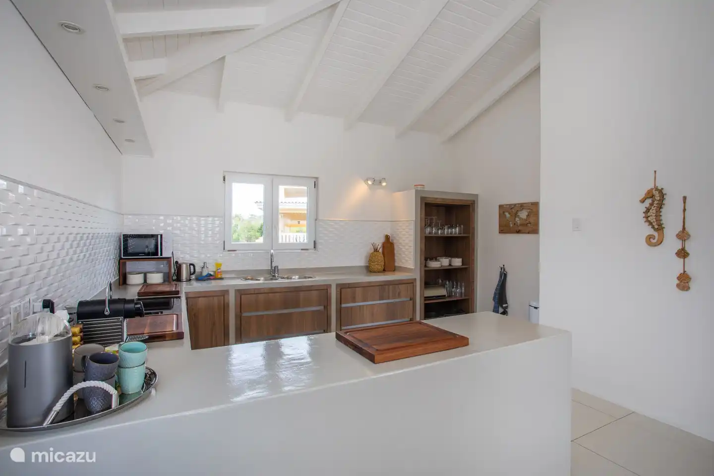 Die Küche mit Backofen, Induktionskochfeld, Kaffeemaschine, Mikrowelle, Geschirrspüler, Geschirr, Shaker usw.