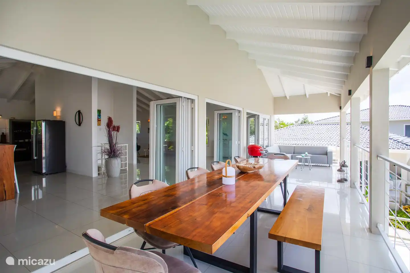 Von der Veranda mit großem Esstisch und Sofa bietet sich ein fantastischer Blick auf Willemstad.