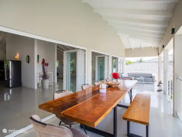 Villa Bunita Bista (Mooi uitzicht) huren in Curaçao, Banda Ariba (oost), Jan Thiel - villa Vanaf de veranda, met een grote eettafel en bankstel een fantastisch uitzicht richting Willemstad.