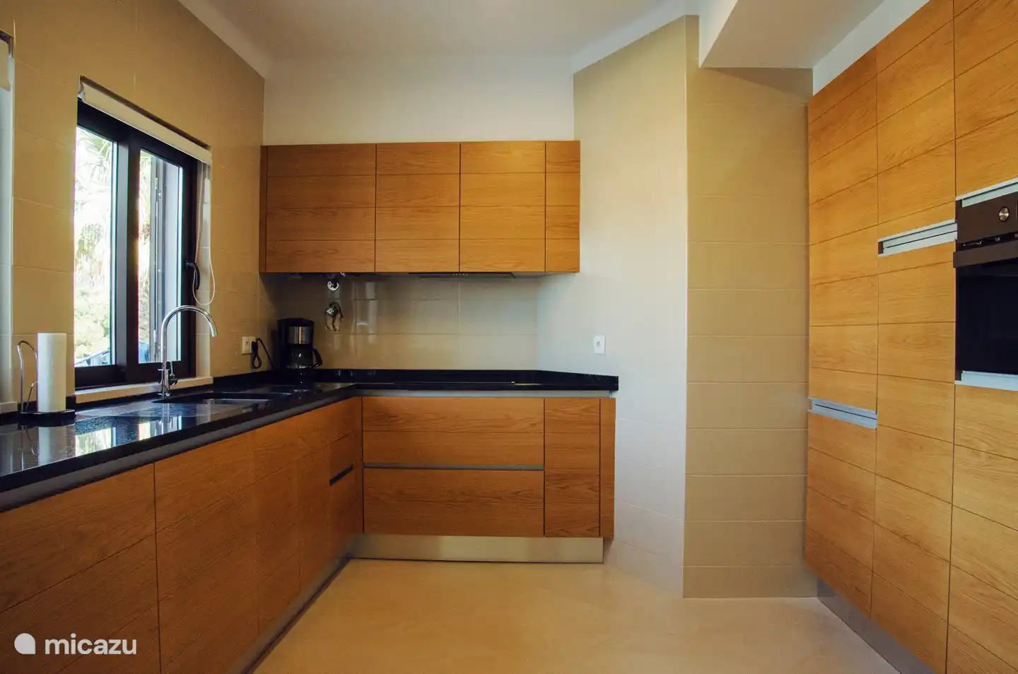 Die offene Küche mit allen grundlegenden Einrichtungen. Es gibt auch einen Geschirrspüler und eine Waschmaschine.