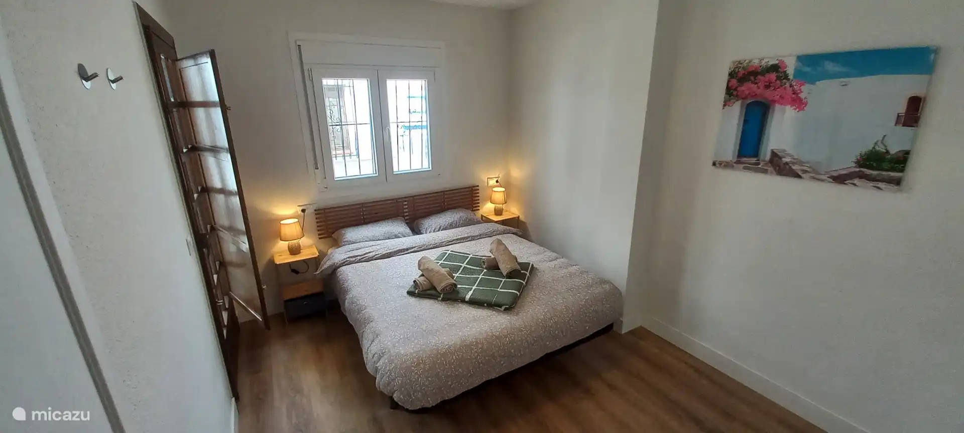 Bedroom with a 2 person bed. With large storage cabinet. There is also a door to the balcony.