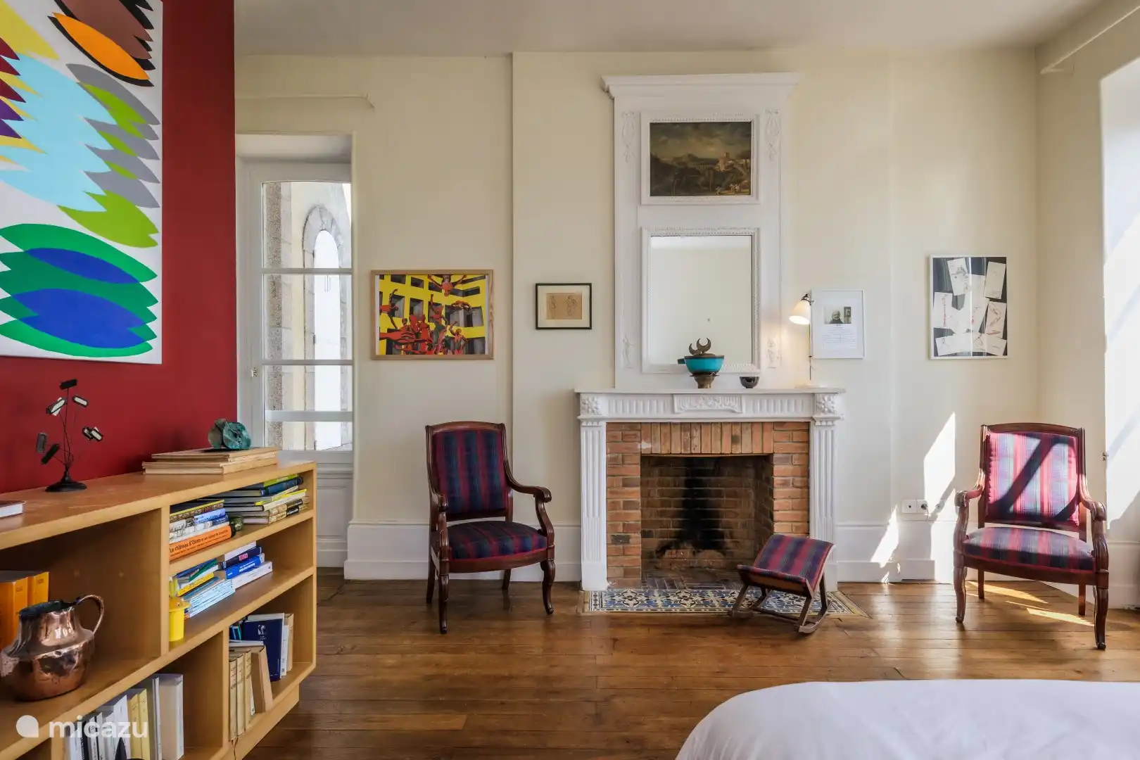 Schlafzimmer mit Sitzgelegenheit und Bücherregal